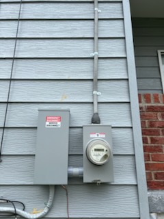 Exterior meter and service disconnect mounted on the side of a home, where a generator inlet or transfer switch ties in